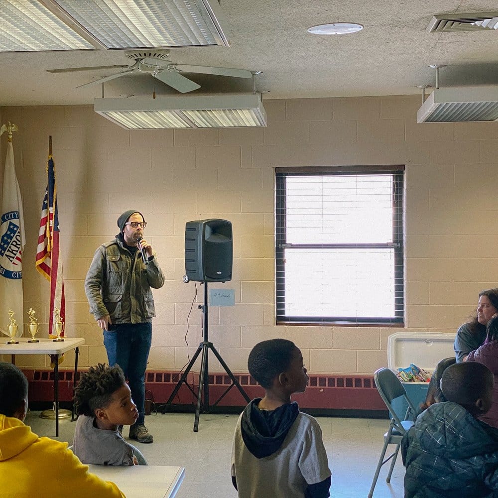 Jon speaking at a football event in Goodyear Heights.